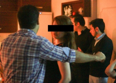 Without hijab, a woman dances with her partner at a party