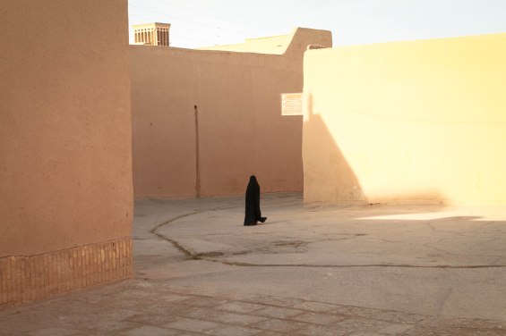 A young girl wearing Chador in the old streets of Yazd, Central Iran